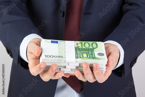 Businessman's hand holding money, euro banknotes.