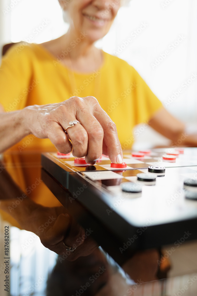 Fototapeta premium Grandma Playing Checkers Board Game In Hospice