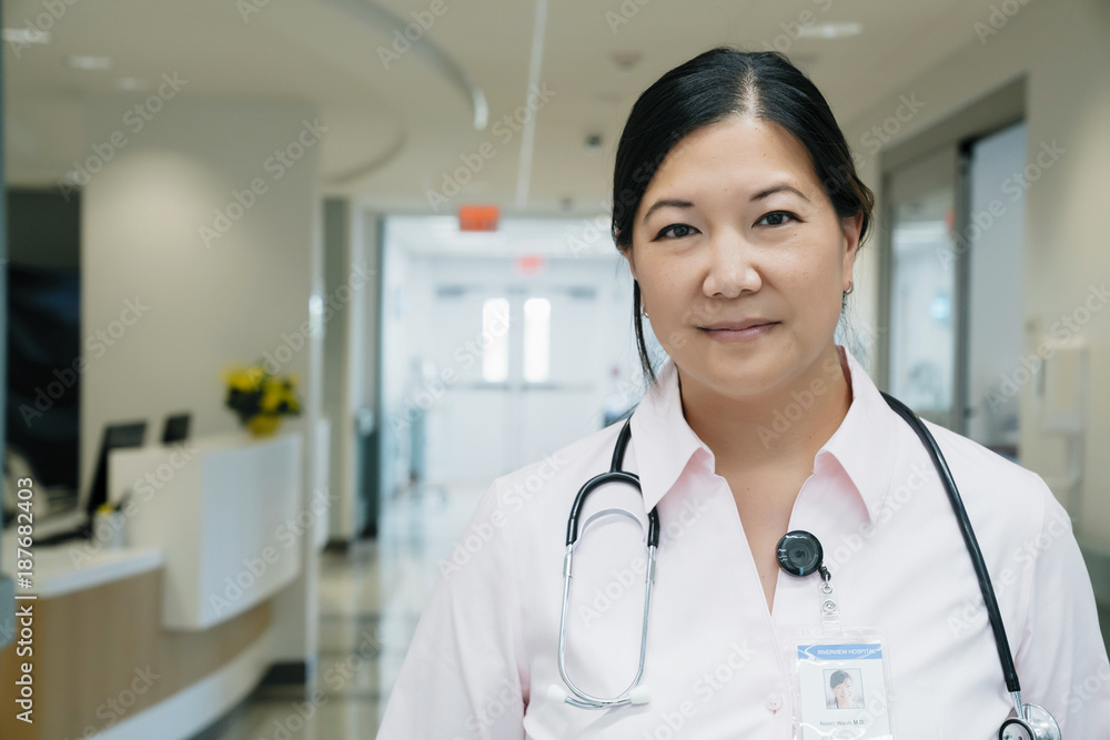 Portrait of confident female doctor with stethoscope in hospital lobby Portrait of confident female doctor with stethoscope in hospital lobby