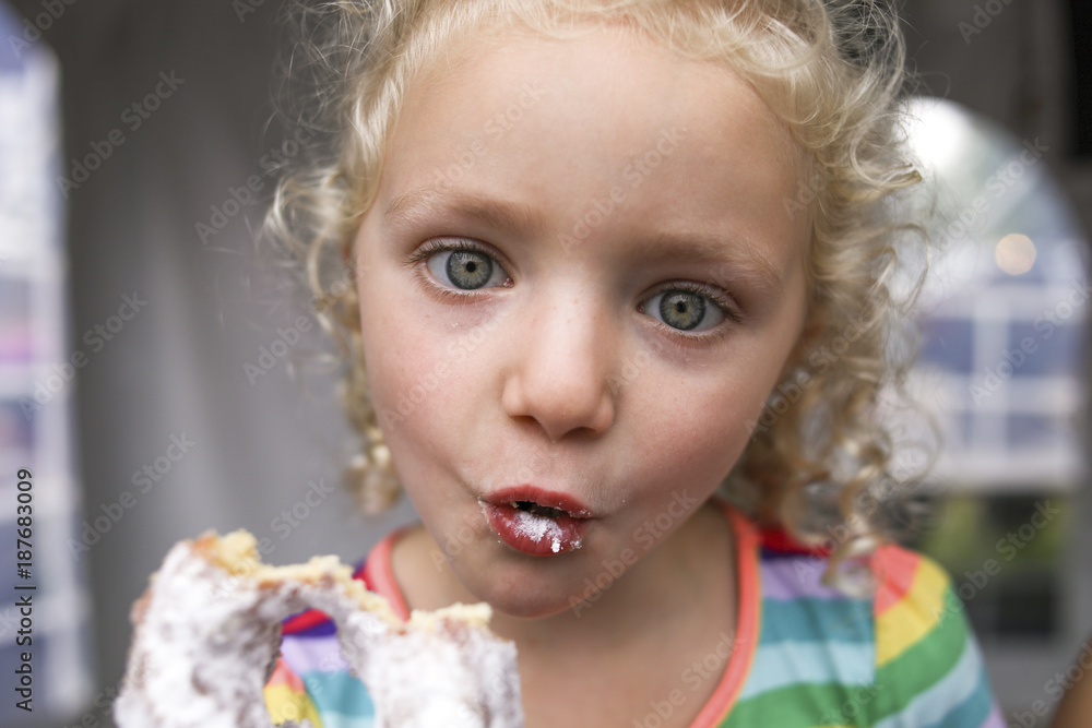 Portrait of cute girl making face while eating donut Portrait of cute girl making face while eating donut