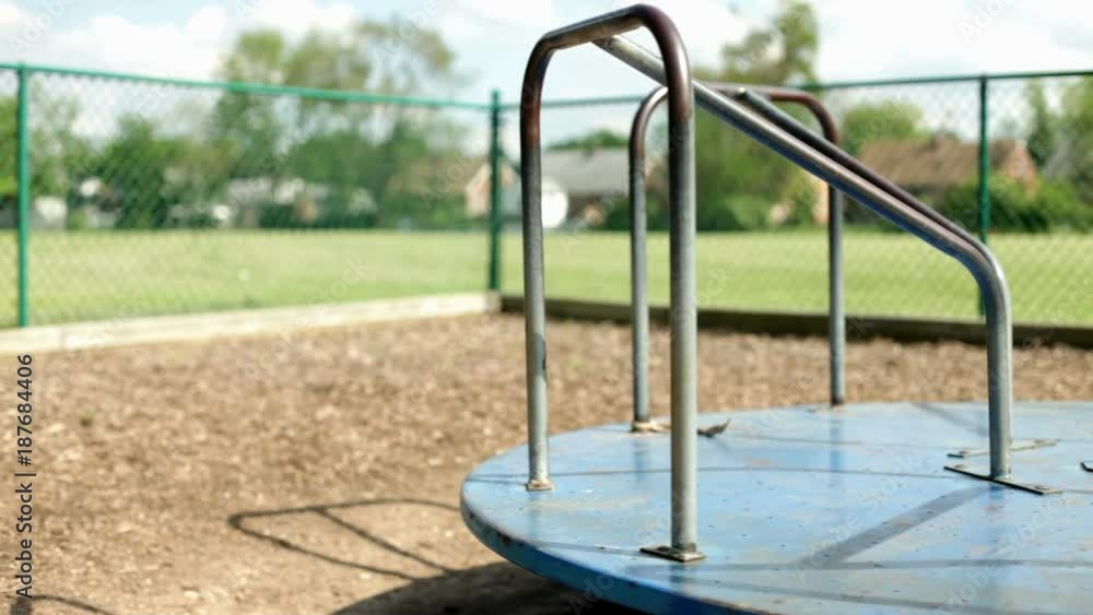 Empty merry go round spinning in kids playground. Empty merry go round spinning in kids playground.