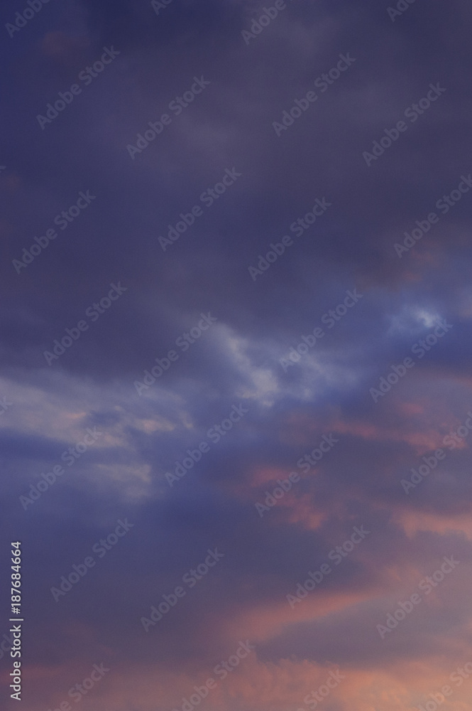 The vertical view of sky background or texture at the sunset time with clouds. Copy space