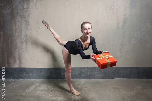Beautiful ballerina balance in one leg and holding red gift box © khosrork