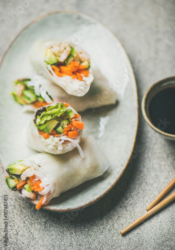 Shrimp and vegetable rice paper spring rolls with sauce and chopsticks, top view, selective focus. Asian cuisine, clean eating, vegetarian, dieting food concept