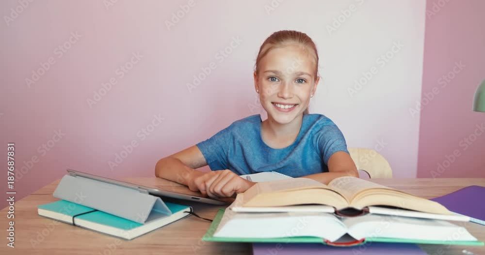 Student using tablet pc at the desk while doing homework Student using tablet pc at the desk while doing homework