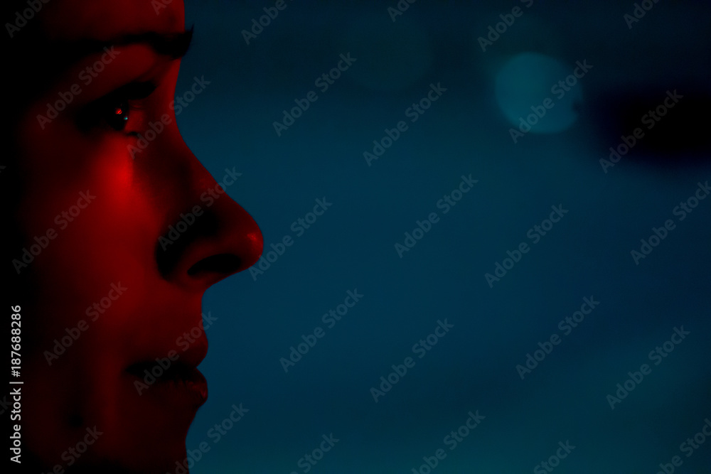 city lights shining on focused young woman's face at night