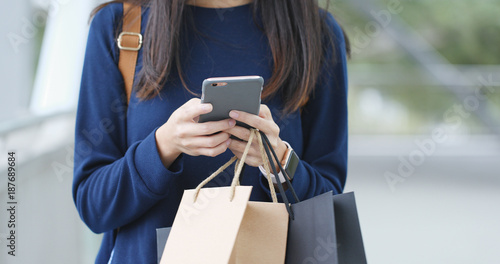 Woman use of cellphone and hold shopping bag