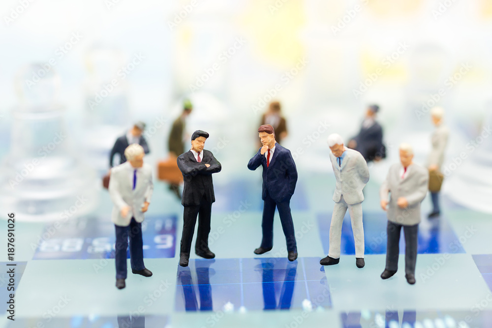 Miniature people, Group Businessmen standing on the chess game, thinking solution for the business game, use as a business competition concept. Miniature people, Group Businessmen standing on the chess game, thinking solution for the business game, use as a business competition concept.