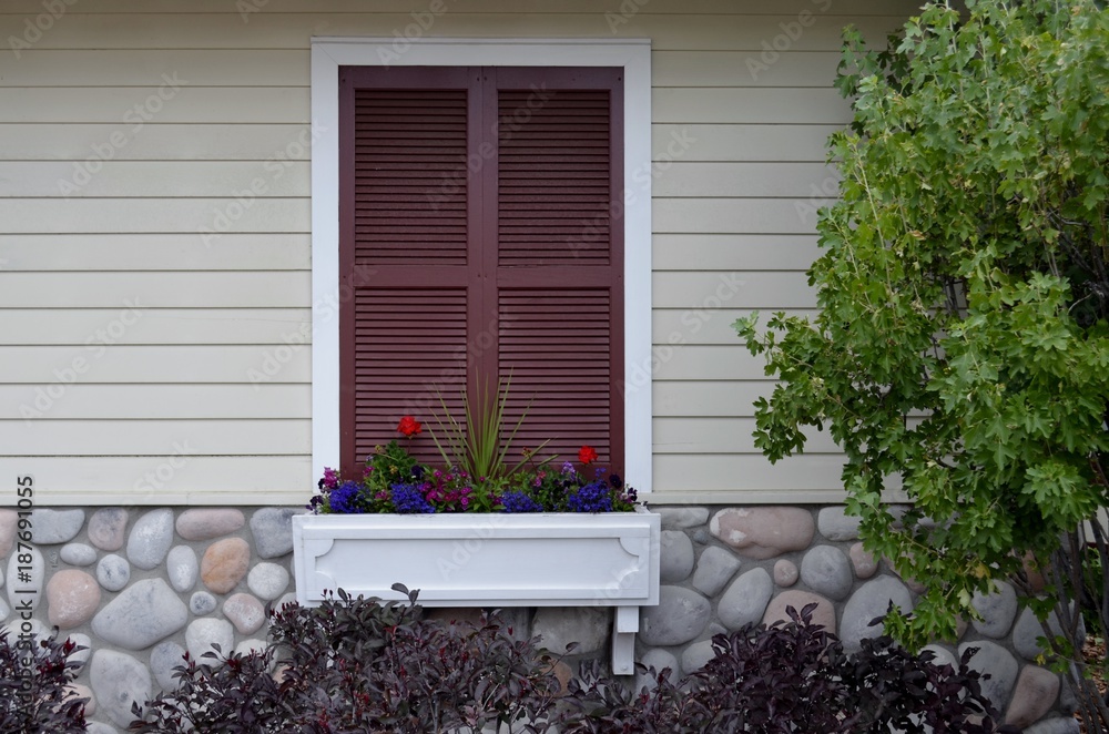Fototapeta premium Exterior window box and flower box with shuttered window