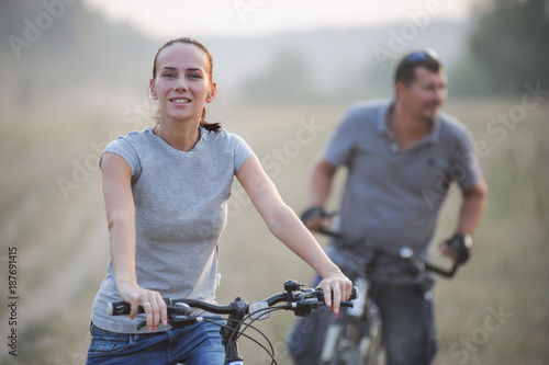 Happy young couple with bicycles in countryside.