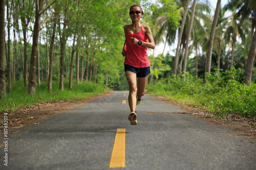 fitness woman runner running on tropical forest trail