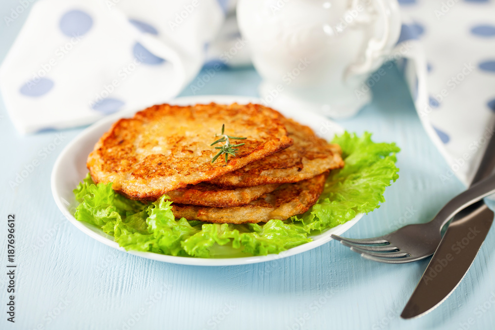 Potato hash brown with salad on a blue background. Selective focus. Rösti . Swiss national dish.