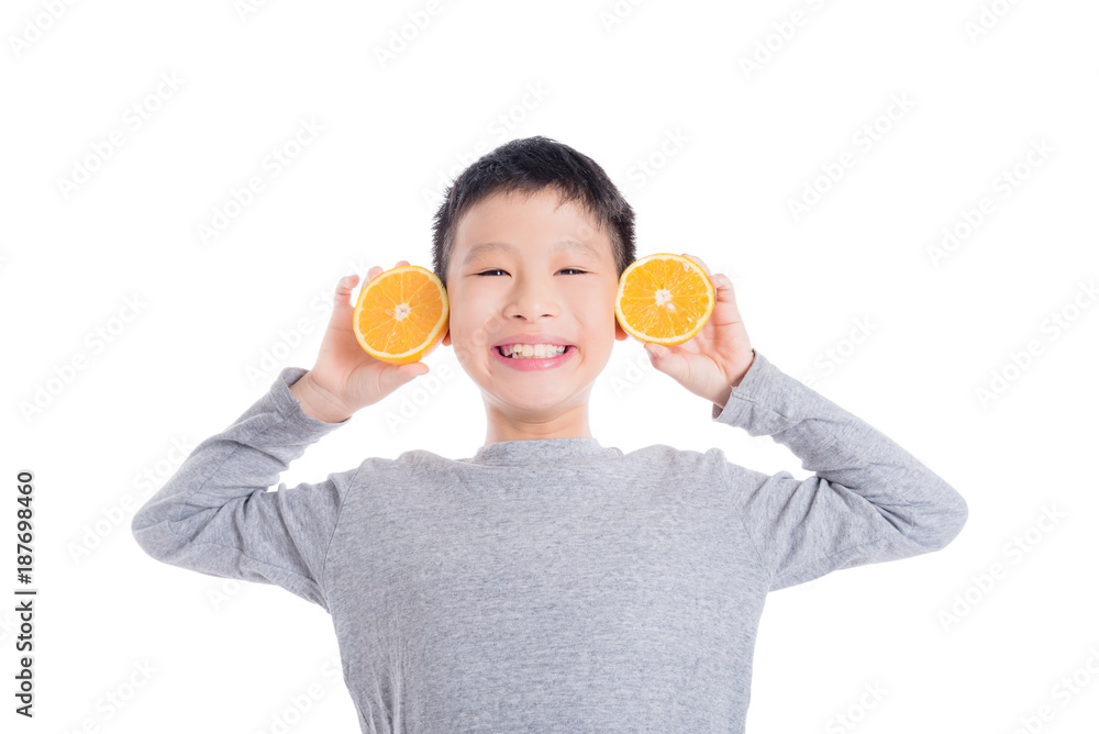 Young asian boy holding orange and smiles over white background Young asian boy holding orange and smiles over white background