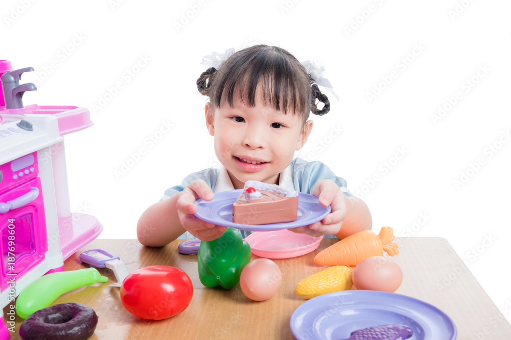 Little asian girl playing with kitchen toy over white background Little asian girl playing with kitchen toy over white background