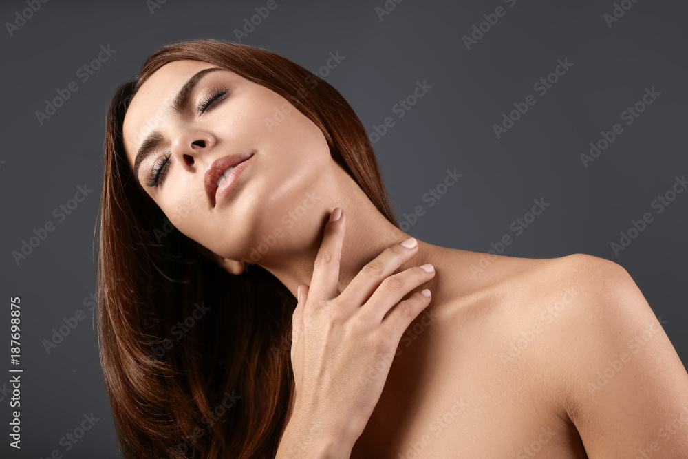 Naklejka premium Beautiful young woman with eyelash extensions on grey background