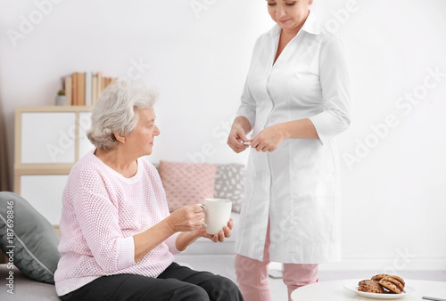 Caregiver giving medicine t...