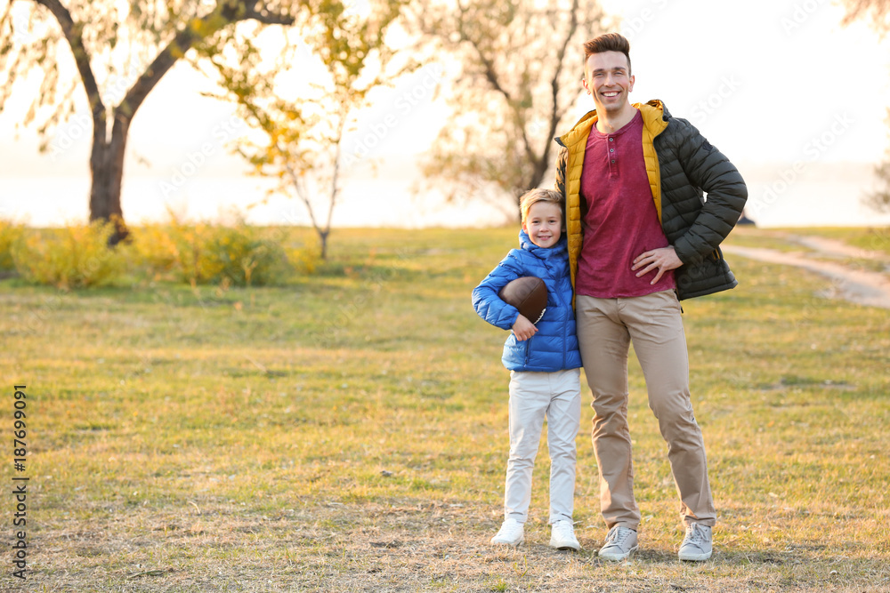 Fototapeta premium Father and little son with rugby ball outdoors