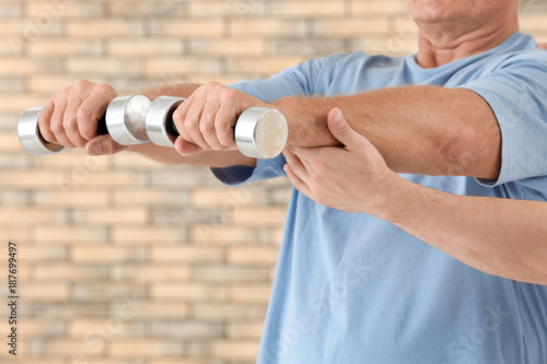 Physiotherapist working with patient on brick wall background