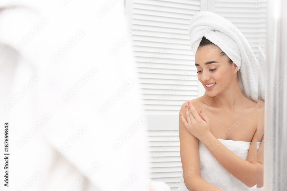 Young woman in white towel using cosmetic product at home Young woman in white towel using cosmetic product at home
