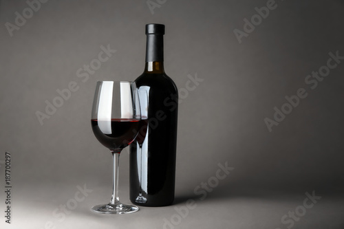 Bottle of wine and glass on gray background