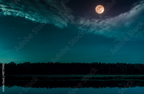 Emerald green sky and full moon at seaboard. Serenity nature background.