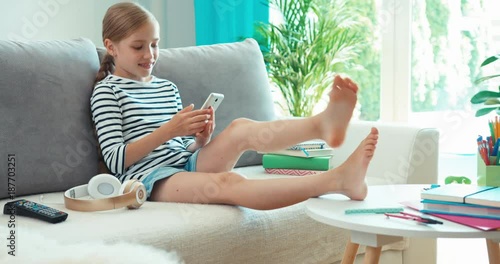 Child using cell phone on sofa