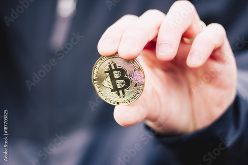 Man holding a bitcoin between his fingers