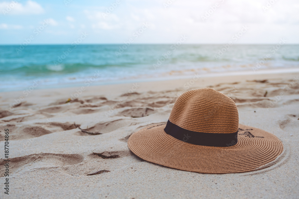 Closeup image of a sun hat or beach hat on the sand by the sea with blue sky background Stock Photo Adobe Stock