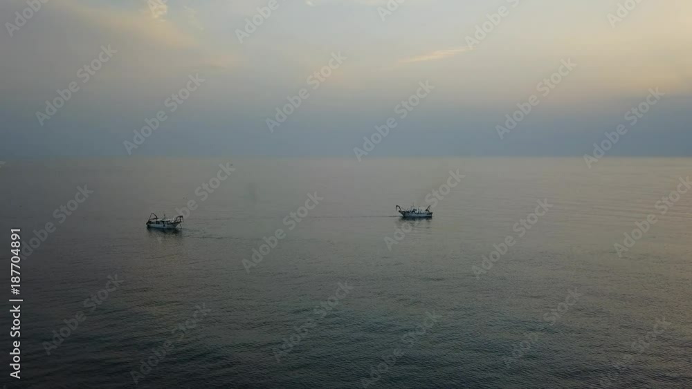 Drone aerial view of the fishing boats pull their nets at the sunrise. Adriatic cost. Emilia Romagna. Italy Drone aerial view of the fishing boats pull their nets at the sunrise. Adriatic cost. Emilia Romagna. Italy