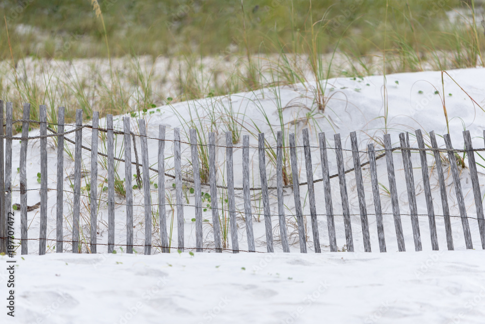 Fototapeta premium Beach Scene with white sand and a fence.