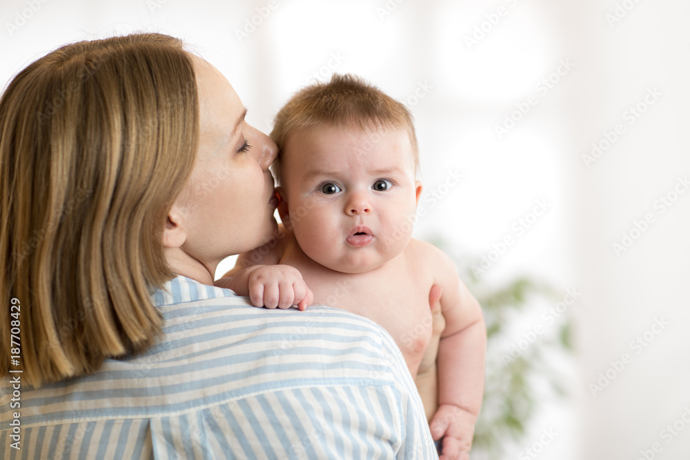 Happy mother kissing her newborn baby son Happy mother kissing her newborn baby son