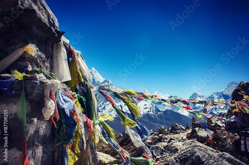 Worn prayer flags hanging against the backdrop of the Himalayas