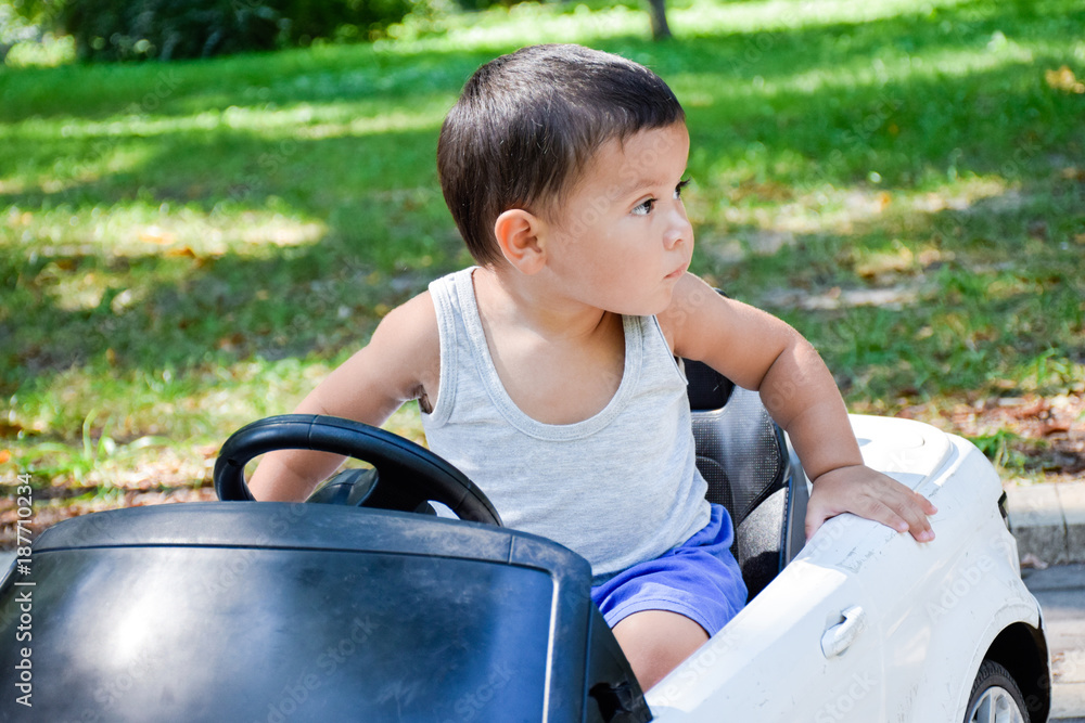 Little serious latin boy in the toy car. Little serious latin boy in the toy car.