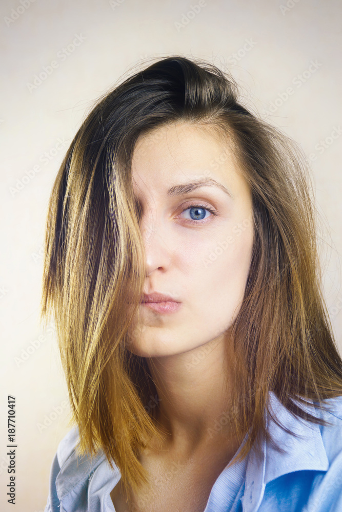 Portrait of young beautiful woman with no makeup and messy hair covering one side of her face. Film style Portrait of young beautiful woman with no makeup and messy hair covering one side of her face. Film style