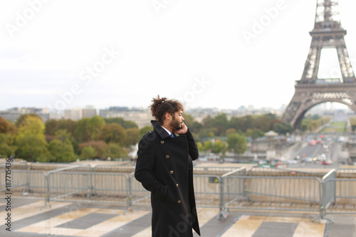 Brazilian male model calling photographer close to Eiffel Tower