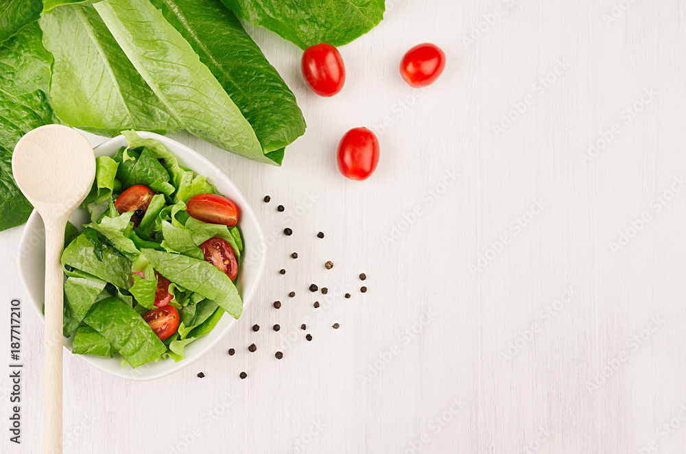 Dieting raw healthy food - fresh green salad with tomatoes, pepper on soft white wood board, top view, copy space. Dieting raw healthy food - fresh green salad with tomatoes, pepper on soft white wood board, top view, copy space.