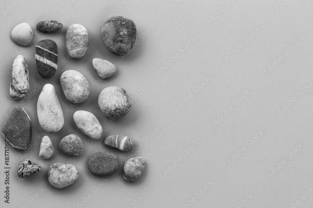 stones pebbles on a gray background with copy space, black and white photo. mock up for text, for phrases, for lettering, for congratulations stones pebbles on a gray background with copy space, black and white photo. mock up for text, for phrases, for lettering, for congratulations