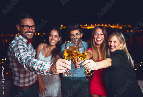 Group of people having a party on the roof, cheering with champagne 