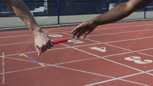 Closeup view of participant handing off baton to next runner, world championship