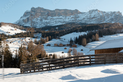 Wooden Fence, Houses and Mountains with Snow in Europe: Dolomites Alps Peaks for Winter Sports