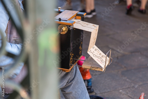 Quadro su tela Street Musician plays Wooden Barrel Organ with Perforated Cardboard for Tourist