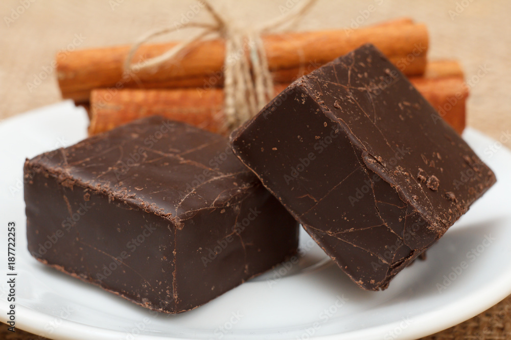 Chocolate candies rectangular shape put on white plate with cinnamon Chocolate candies rectangular shape put on white plate with cinnamon