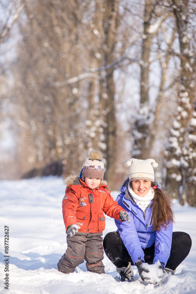 woman with a small child in the park for a winter walk. woman with a small child in the park for a winter walk.