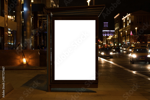 Blank white mock up of vertical light box in a bus stop at night