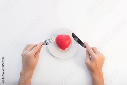 composition on a white background of the plates, heart-shaped, hands with fork and knife