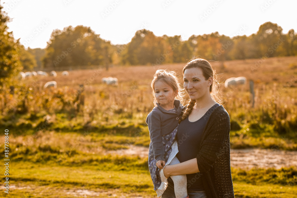 Fototapeta premium Junge Mutter spaziert mit ihrer Tochter