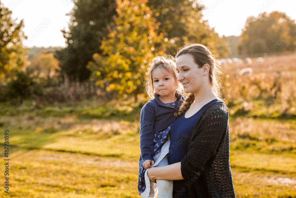 Fototapeta premium Junge Mutter spaziert mit ihrer Tochter 