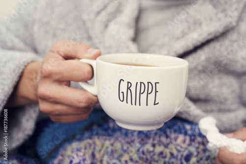 ill man and mug with word grippe, flu in french photo