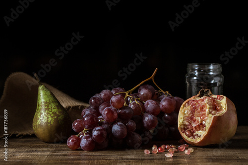 Pictorial still life with grapes, pears and pomegranate.