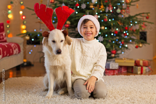 Boy and dog by Christmas tree
